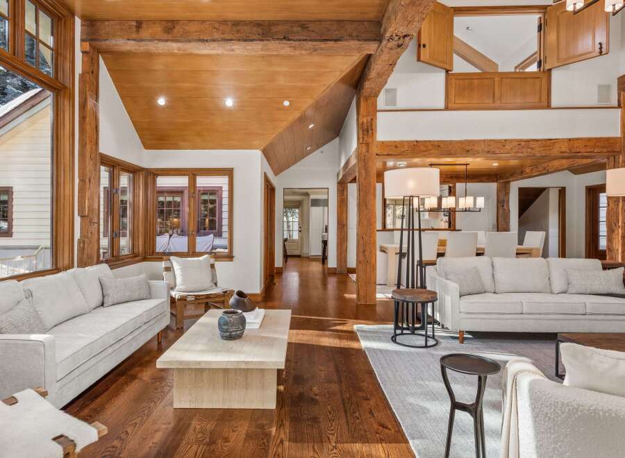 This stunning living room boasts a vaulted ceiling with exposed wooden beams, creating a warm and inviting atmosphere.