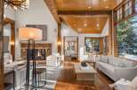 This stunning living room boasts a cozy fireplace, large windows offering breathtaking views, and hardwood floors.