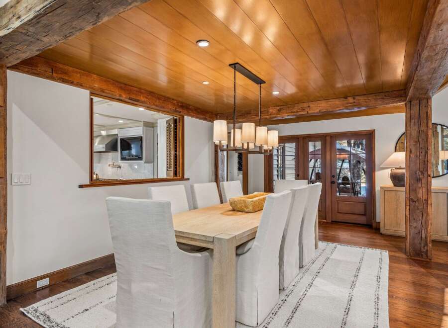 This stunning dining room boasts a beautiful wooden ceiling with exposed beams, creating a warm and inviting atmosphere.