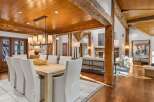 This stunning home boasts a spacious dining area with a large wooden table and comfortable white chairs, perfect for family gatherings.