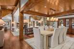 This stunning home boasts a spacious open floor plan with exposed wooden beams, hardwood floors, and large windows offering abundant natural light.