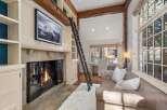 Cozy mountain retreat with a stunning stone fireplace, built-in bookshelves, and a charming window seat.