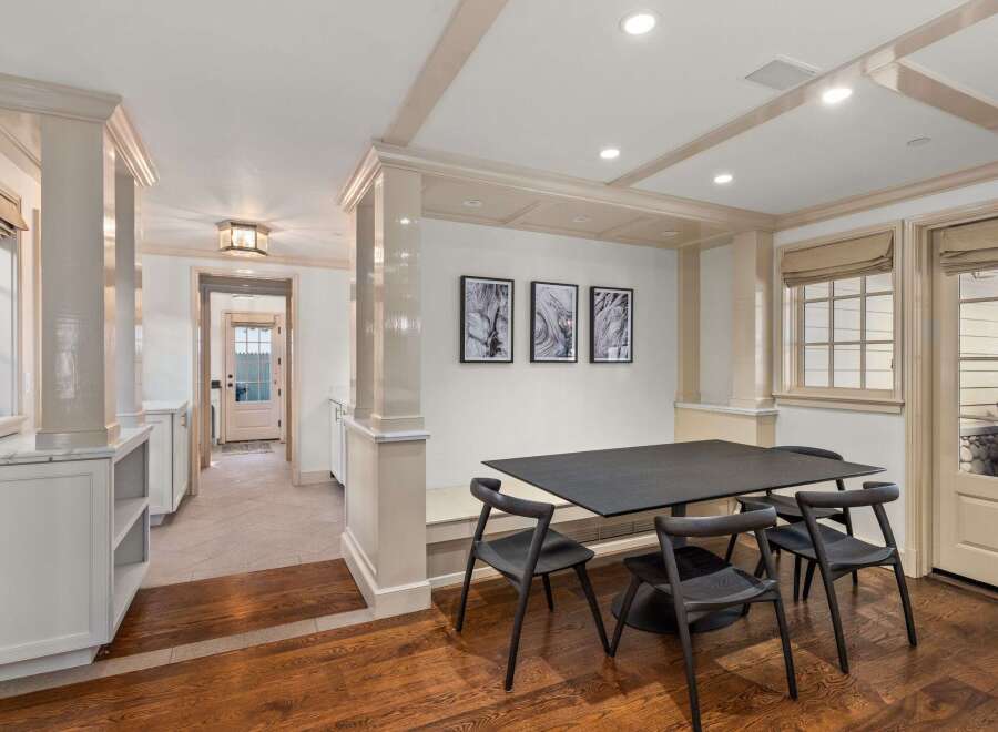 This stunning dining area boasts a sleek, modern table and chairs, complemented by hardwood floors and built-in cabinetry.