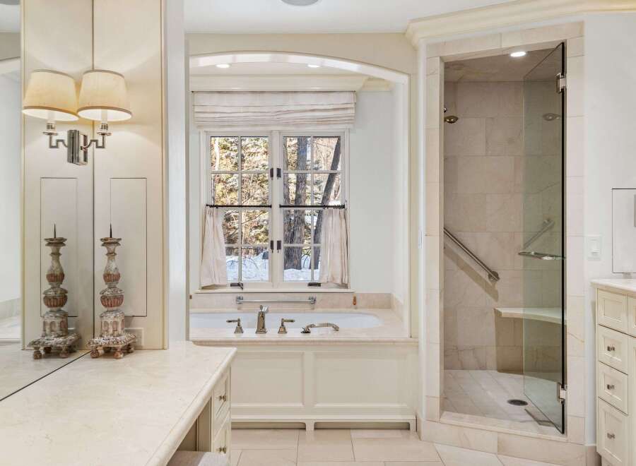 This luxurious bathroom boasts a freestanding bathtub, a walk-in shower with glass enclosure, and elegant fixtures.