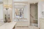 This luxurious bathroom boasts a freestanding bathtub, a walk-in shower with glass enclosure, and elegant fixtures.