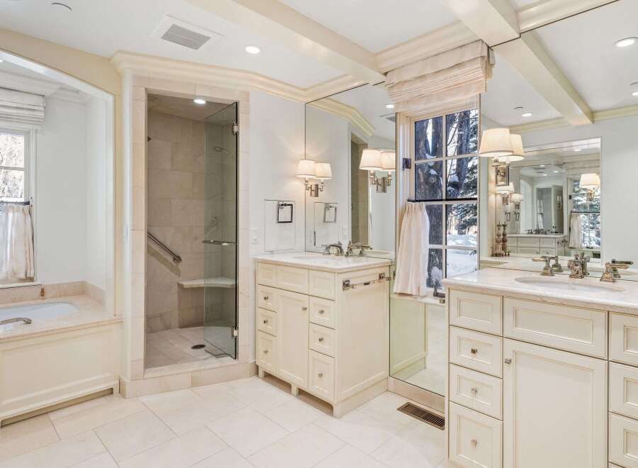 This luxurious bathroom boasts a spacious design with a large soaking tub, walk-in shower, and dual vanities.