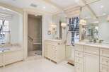 This luxurious bathroom boasts a spacious design with a large soaking tub, walk-in shower, and dual vanities.