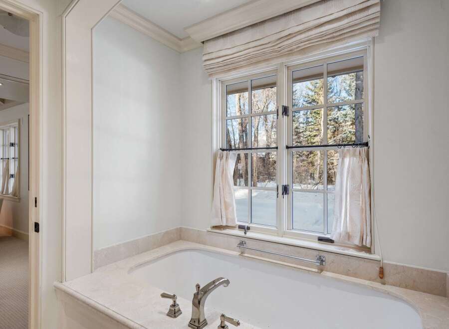 This luxurious bathroom boasts a freestanding bathtub with marble surround, offering a spa-like experience.
