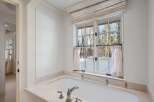 This luxurious bathroom boasts a freestanding bathtub with marble surround, offering a spa-like experience.