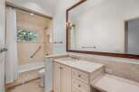 This luxurious bathroom boasts a spacious vanity with marble countertops and ample storage, complemented by elegant off-white cabinets.