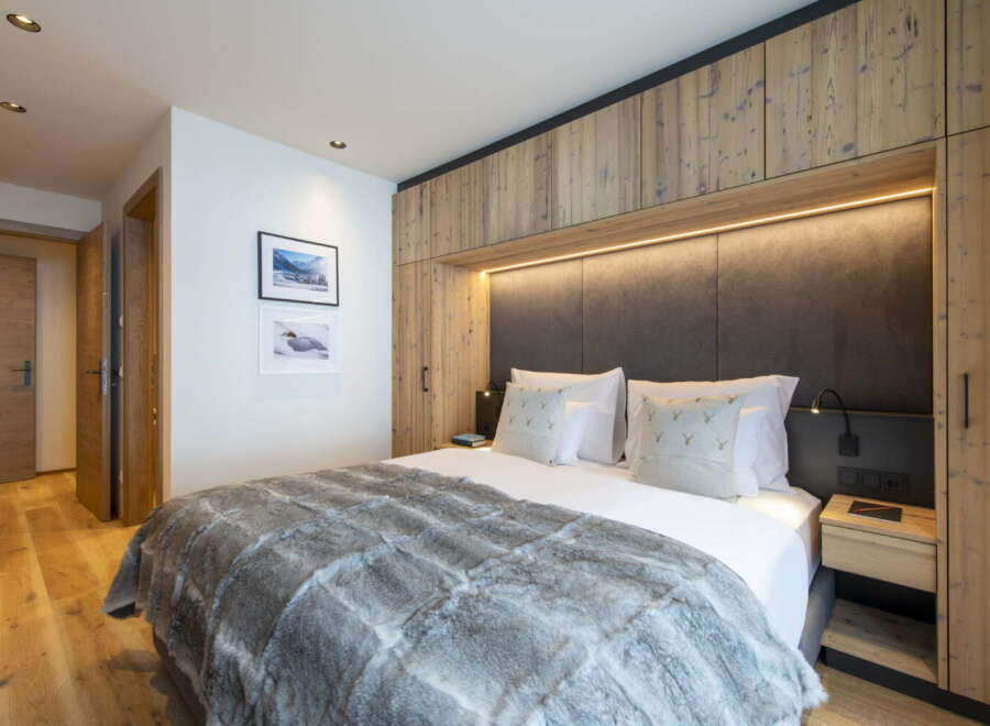 This luxurious bedroom boasts a king-size bed with a plush faux fur throw, perfect for cozy nights.