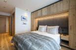 This luxurious bedroom boasts a king-size bed with a plush faux fur throw, perfect for cozy nights.