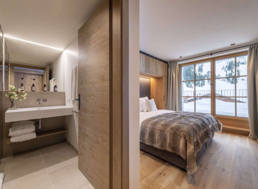 This stunning bedroom boasts a cozy atmosphere with its wooden features and a luxurious faux fur throw.