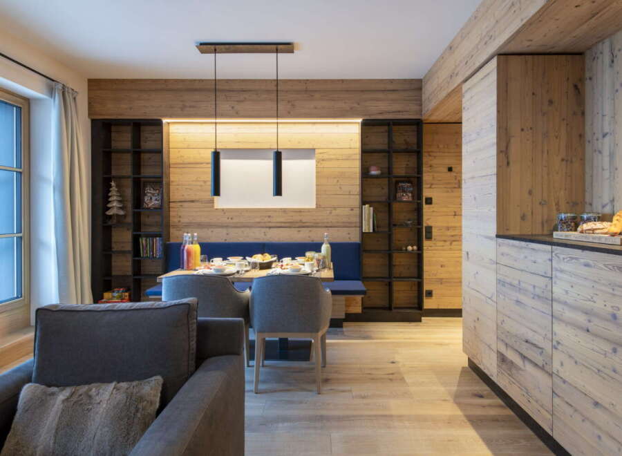 This stunning apartment boasts a spacious open-plan living area with a cozy seating arrangement and a dining table set for a delightful meal.