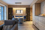 This stunning apartment boasts a spacious open-plan living area with a cozy seating arrangement and a dining table set for a delightful meal.