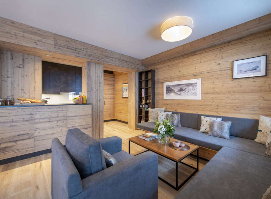 This stunning apartment boasts a spacious living area with a cozy L-shaped sofa, perfect for relaxing after a day on the slopes.