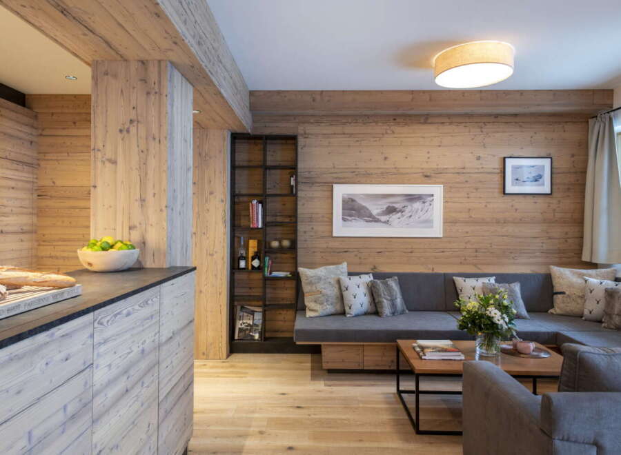 This stunning apartment boasts a spacious open-plan living area with a cozy L-shaped sofa, perfect for relaxing after a day on the slopes.