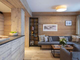 This stunning apartment boasts a spacious open-plan living area with a cozy L-shaped sofa, perfect for relaxing after a day on the slopes.