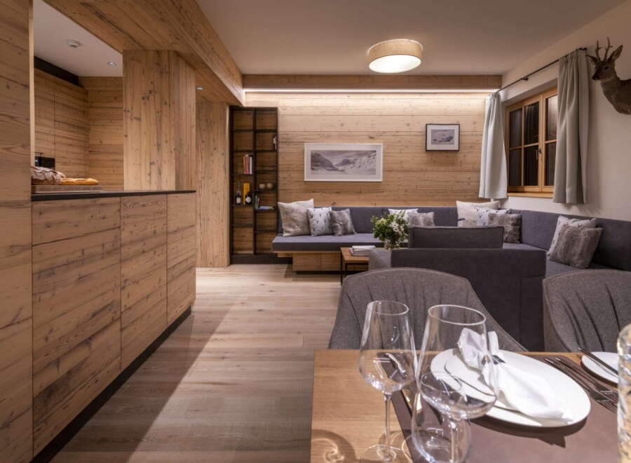 This stunning apartment boasts a spacious open-plan living area with a cozy seating arrangement and a fully equipped kitchen.