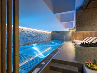 Indulge in tranquility at our luxurious hotel, featuring a stunning indoor pool bathed in soothing blue light.