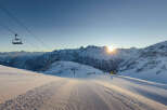 Ski resort in the mountains with a chairlift and groomed slopes.