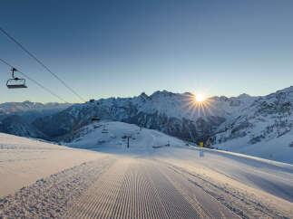 Ski resort in the mountains with a chairlift and groomed slopes.