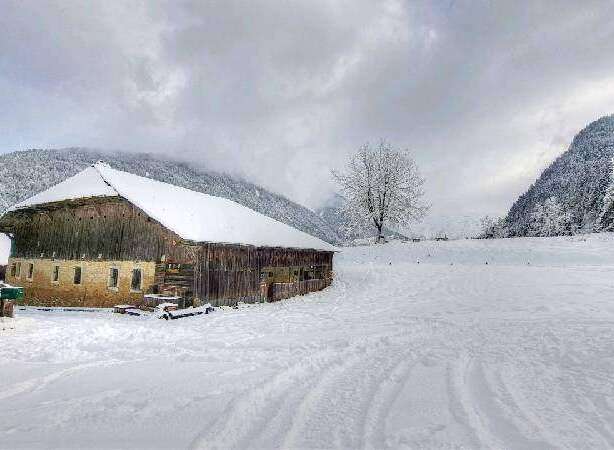 Secluded mountain barn in a snowy landscape, perfect for a winter getaway.