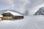 Secluded mountain barn in a snowy landscape, perfect for a winter getaway.