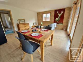 This charming property features a cozy dining area with a wooden table and stylish chairs, perfect for enjoying meals.