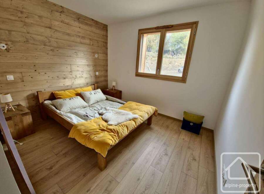 This charming bedroom features a cozy wooden bed frame and a warm, inviting atmosphere.