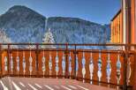 Enjoy breathtaking mountain views from your private balcony, featuring a stylish wooden railing.