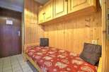 Cozy single bed tucked away in a charming wooden alcove, perfect for a peaceful night's sleep.
