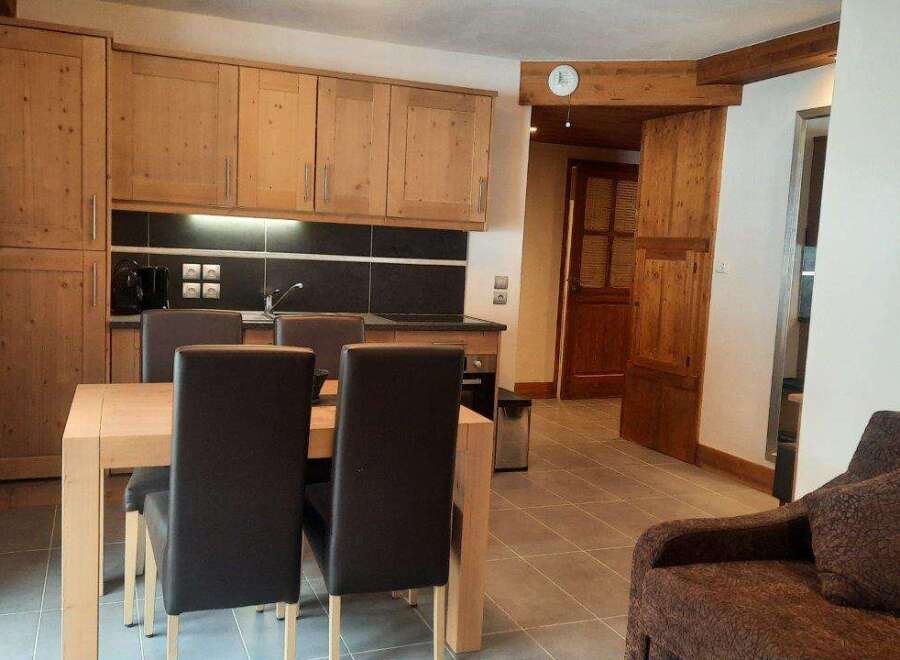 This cozy apartment boasts a fully equipped kitchen with light wood cabinets and modern appliances, perfect for preparing meals after a day on the slopes.