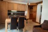 This cozy apartment boasts a fully equipped kitchen with light wood cabinets and modern appliances, perfect for preparing meals after a day on the slopes.