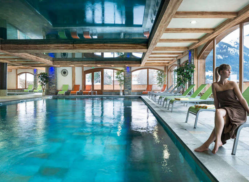 Relax and rejuvenate in our luxurious indoor pool area, complete with comfortable lounge chairs and stunning mountain views.
