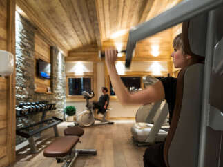 Luxury chalet gym with wooden features and state-of-the-art equipment.