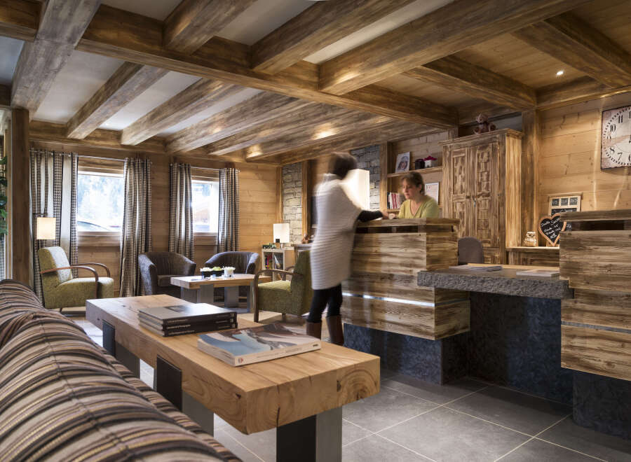 This stunning hotel lobby boasts a rustic-chic design with exposed wooden beams, a cozy fireplace, and comfortable seating areas.