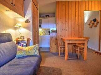Cozy studio apartment featuring a comfortable sofa bed, a well-equipped kitchenette, and a dining area.