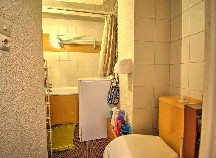 This cozy bathroom boasts a bathtub, toilet, and washing machine, perfect for a comfortable stay.