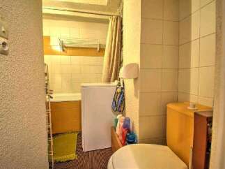 This cozy bathroom boasts a bathtub, toilet, and washing machine, perfect for a comfortable stay.