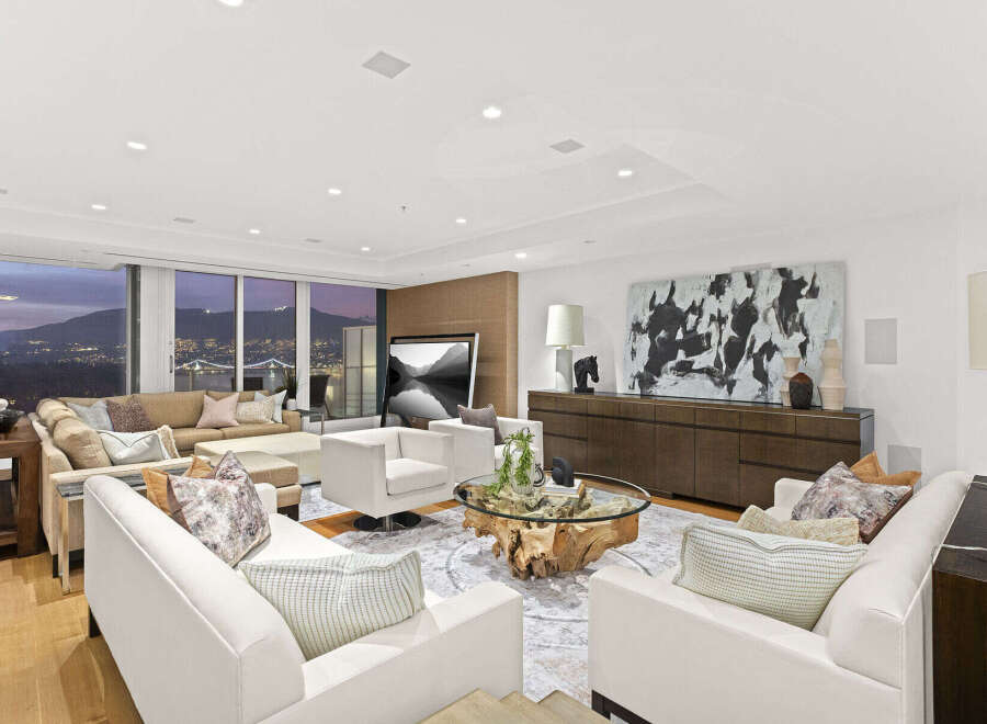 This luxurious living room boasts breathtaking panoramic views, floor-to-ceiling windows showcasing stunning city and mountain vistas.