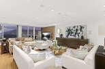 This luxurious living room boasts breathtaking panoramic views, floor-to-ceiling windows showcasing stunning city and mountain vistas.