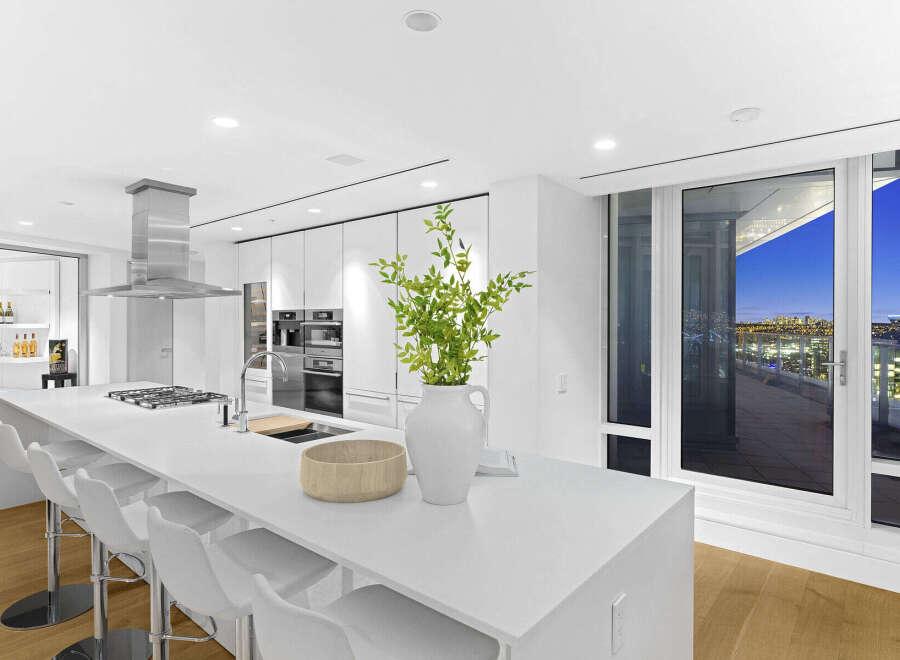 This luxurious condo boasts a stunning modern kitchen with high-end appliances and a spacious island, perfect for entertaining.