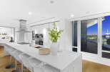 This luxurious condo boasts a stunning modern kitchen with high-end appliances and a spacious island, perfect for entertaining.