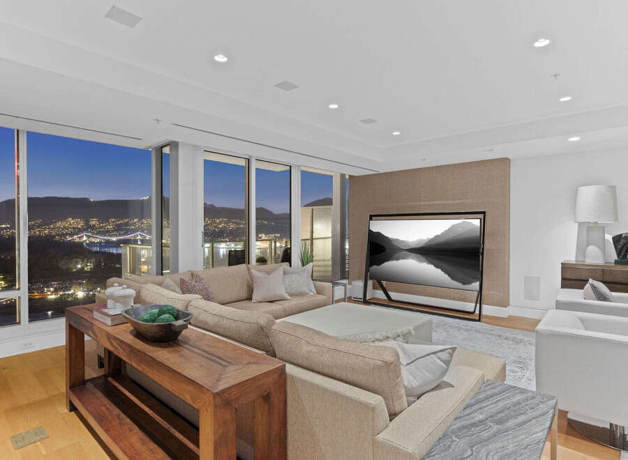 Luxury condo with breathtaking panoramic views of city lights and mountains at night.