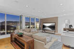 Luxury condo with breathtaking panoramic views of city lights and mountains at night.