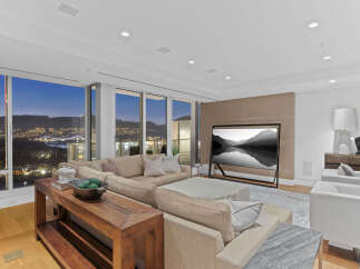Luxury condo with breathtaking panoramic views of city lights and mountains at night.
