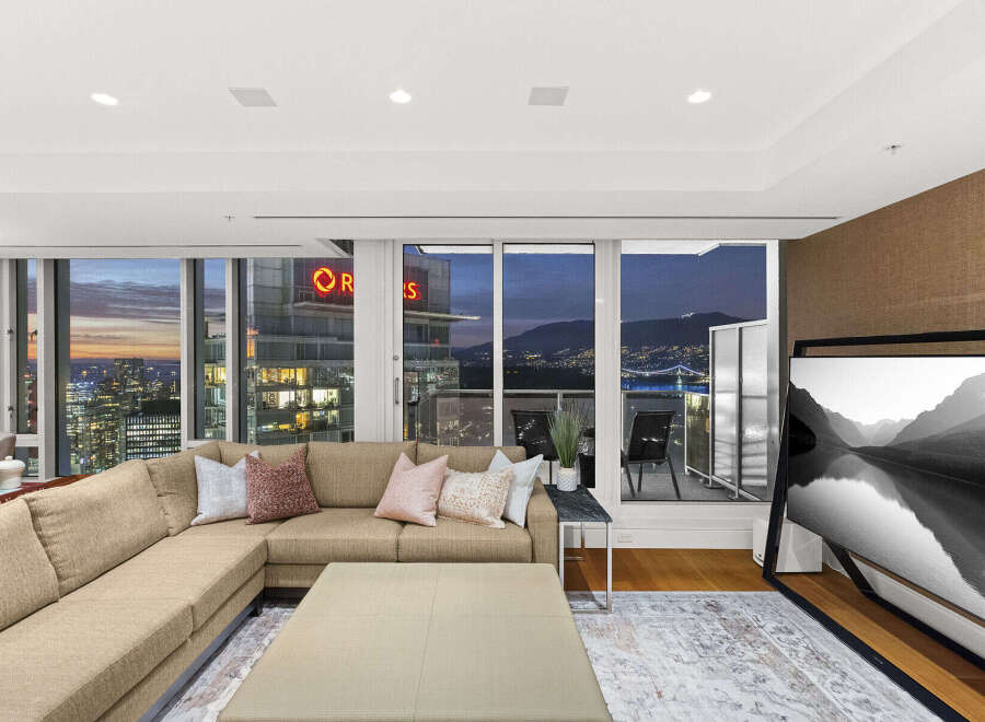 This luxurious condo boasts breathtaking panoramic city and mountain views from its floor-to-ceiling windows, creating a bright and airy living space.