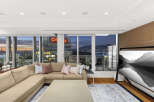 This luxurious condo boasts breathtaking panoramic city and mountain views from its floor-to-ceiling windows, creating a bright and airy living space.