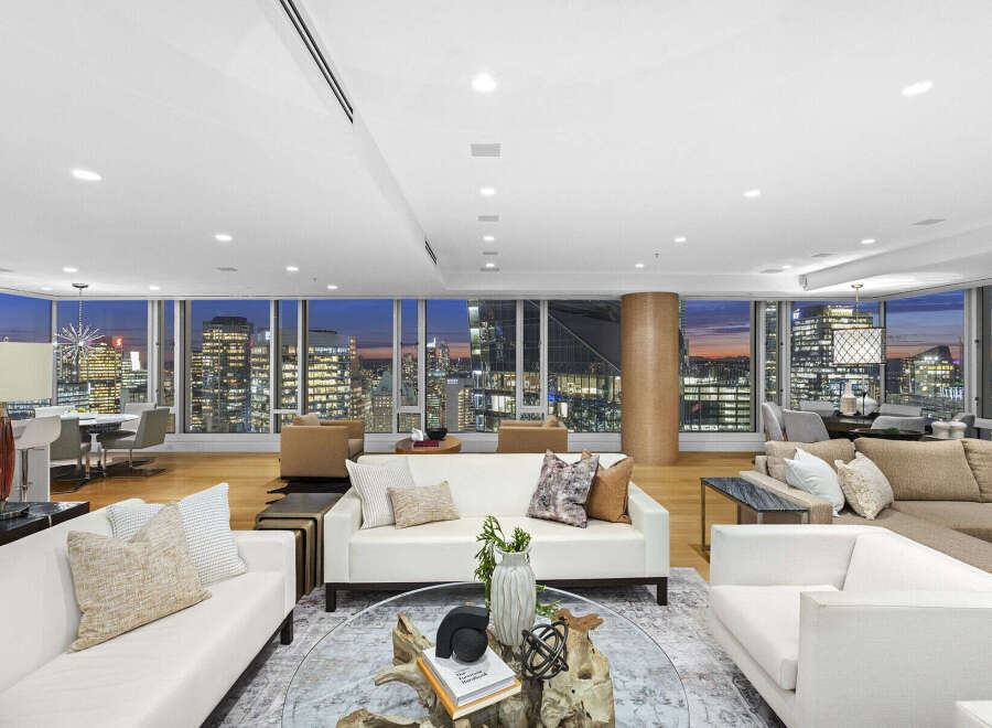 This luxurious penthouse boasts breathtaking panoramic city views from its expansive floor-to-ceiling windows, creating a bright and airy atmosphere.